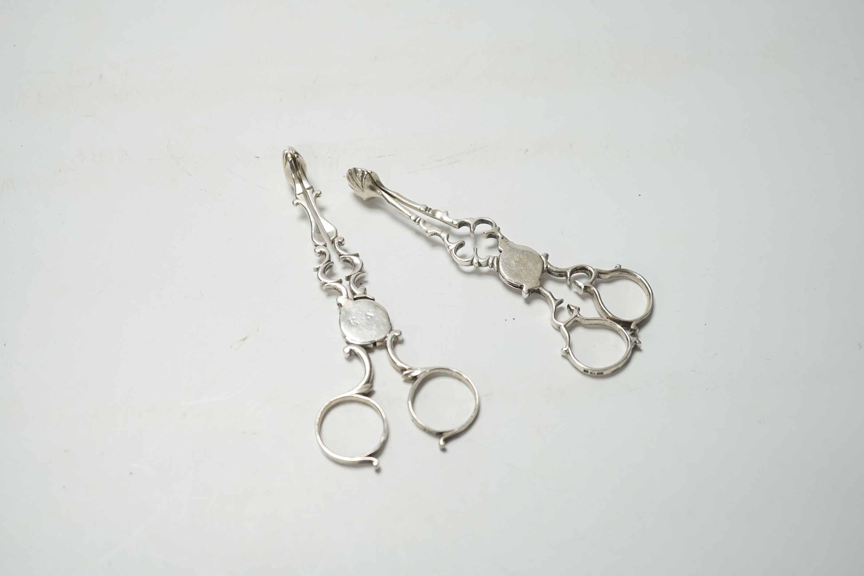 A pair of mid 18th century silver sugar nips, 12.3 cm and a pair of George V silver sugar nips.